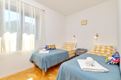 sypialnia z 2 łóżkami i oknem w obiekcie Argo Apartmani w miejscowości Mali Lošinj