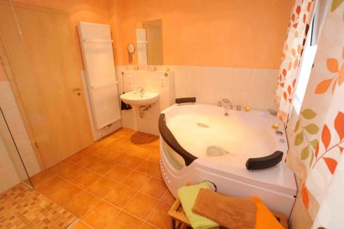a bathroom with a bath tub and a sink at Wetekams Ferienwohnung W5 in Diemelstadt 