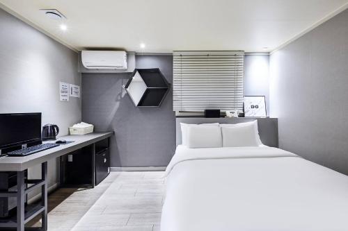 a bedroom with a bed and a desk with a computer at Yam hotel in Guri