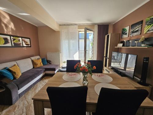 sala de estar con sofá y mesa con sillas en Apartment Pegaz & Aqua Marina, en Świnoujście