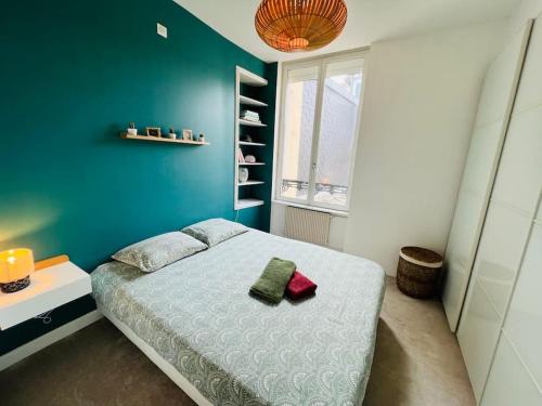 une chambre avec un lit et un mur bleu dans l'établissement Le Repère - T2 Haut de Gamme Rouen Centre, à Rouen