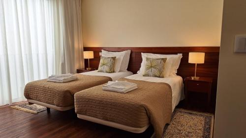 a hotel room with two beds and a window at Theo's City House in Funchal