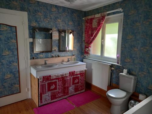 een badkamer met een wastafel en een toilet en een raam bij Bellavie2 in La Bresse