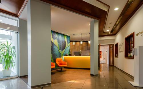 an office lobby with an orange chair and a yellow counter at Albhotel Fortuna in Riederich