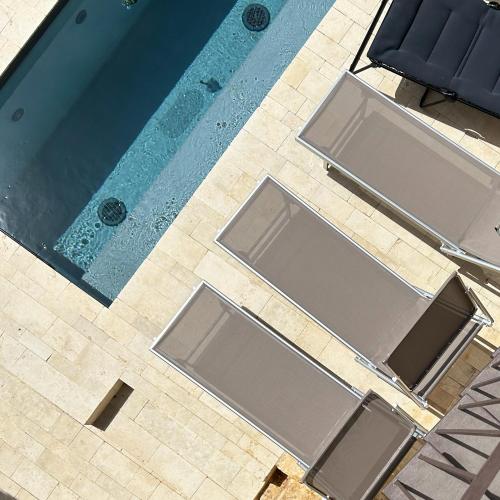 an overhead view of a swimming pool with empty chairs at Villa Edda in Noto