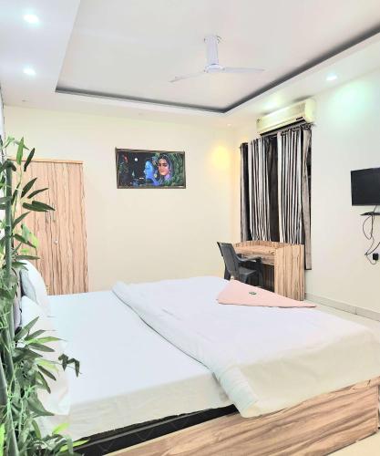 a bedroom with two beds and a desk at Mauji's Villa Hotel & Guest House in Prayagraj