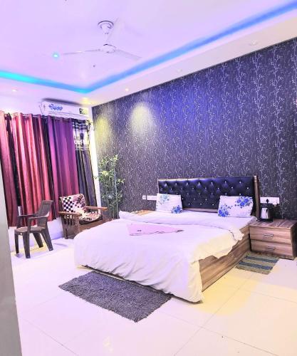 a bedroom with a bed and a purple wall at Mauji's Villa Hotel & Guest House in Prayagraj