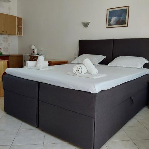 a large black bed with two white towels on it at ANNA MARIA Studios in Potos