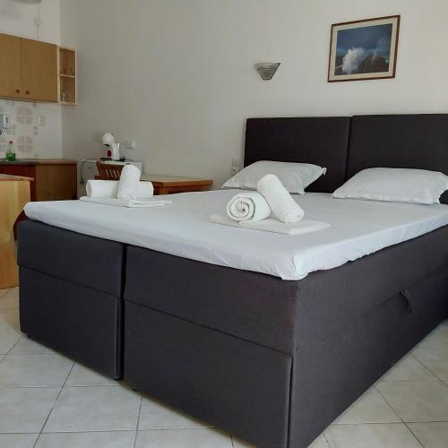 a large black bed with two white towels on it at ANNA MARIA Studios in Potos