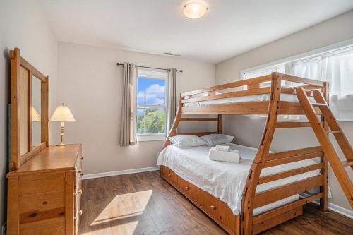 a bedroom with a bunk bed and a ladder at Spacious 4BDR Blue Haven Cottage in Grand Haven 150 in Grand Haven