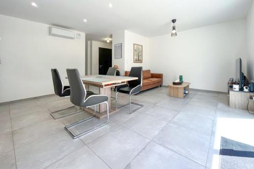 - un salon avec une table, des chaises et un canapé dans l'établissement Magnifique T3, à Bastelicaccia