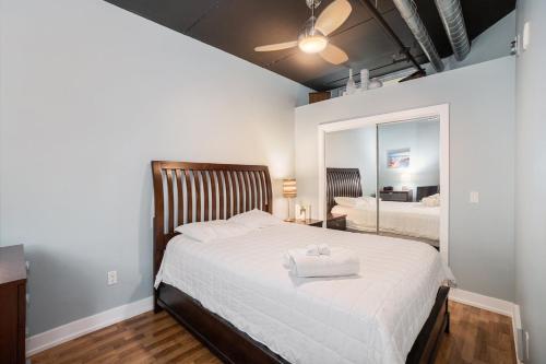 a bedroom with a large white bed with a mirror at Luxurious 2BDR Loft Condo with Stunning Views in Grand Haven in Grand Haven