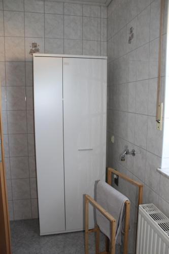 a bathroom with a large white cabinet and a chair at Ruhige Ferienwohnung in der Rhöner Natur in Schönau an der Brend