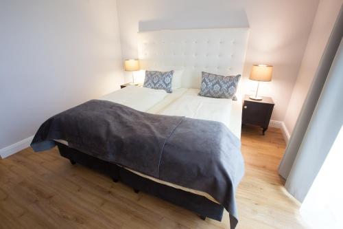 a bedroom with a large bed and two lamps at Hotel Rheinischer Hof Bad Soden in Bad Soden am Taunus