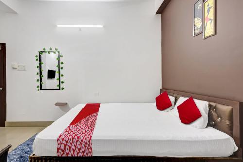 a bedroom with a bed with red pillows at OYO Odalbakra Near ACA Stadium in Dispur