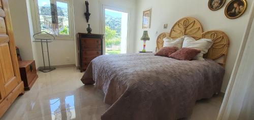 une chambre avec un grand lit avec une tête de lit en bois dans l'établissement Charmant appartement en Rez de jardin, à Sartène