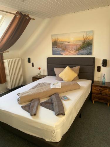 a bedroom with a large bed with towels on it at Bistro-zur-Quelle in Minden