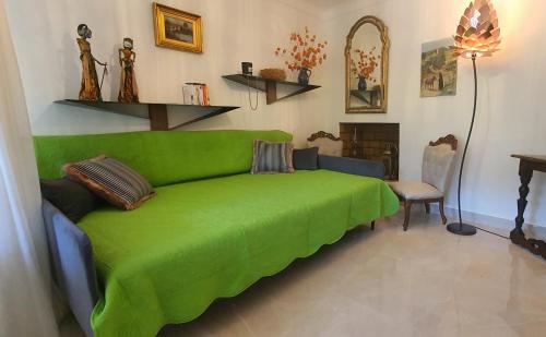 a green couch in a living room with a table at Charmant appartement en Rez de jardin in Sartène