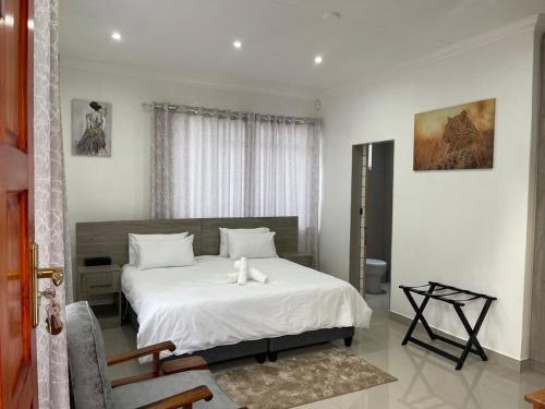 a bedroom with a bed with a teddy bear on it at Serenity Guest Lodge in Kokstad