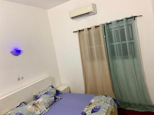 a small bedroom with a bed and a shower at Appartement Meublé in Cadjèhoun