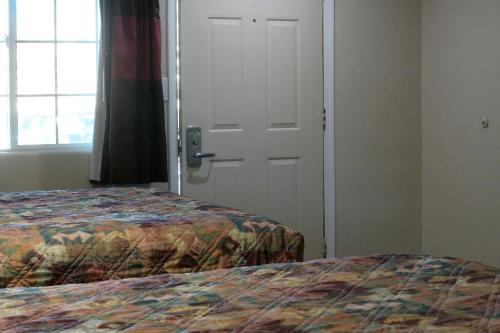 a bedroom with a bed and a white door at A-1 Budget Motel in Klamath Falls