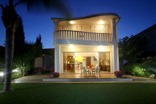 a large white house with a table and chairs at Chelidonia Larnaca Seafront Villa in Meneou