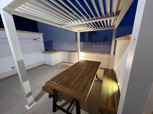 a room with a wooden table and a bench at OWNER ITALY - APARTMENT A in Torre San Giovanni Ugento