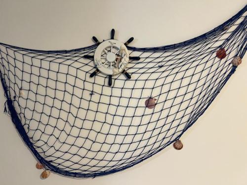 a netting clock hanging on a wall at OWNER ITALY - APARTMENT A in Torre San Giovanni Ugento