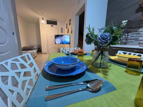 a table with plates and utensils on top of it at OWNER ITALY - APARTMENT A in Torre San Giovanni Ugento