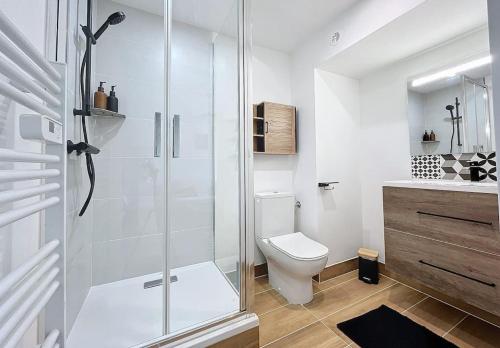 une salle de bain blanche avec douche et toilettes dans l'établissement Appart'HomeStudio - Agen, à Agen