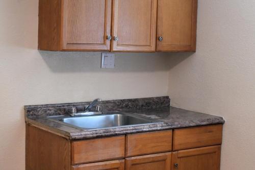 a kitchen with a sink and wooden cabinets at A-1 Budget Motel in Klamath Falls