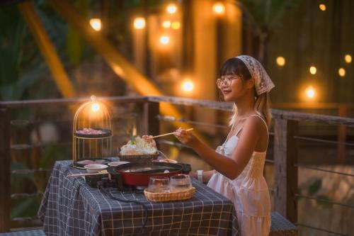 a woman is standing next to a table with a cake at Voraman B-One in Chiang Mai