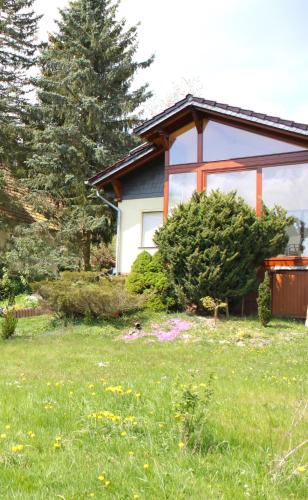 a house in a yard with a field of grass at DAS Ferienhaus Waldblick in Güntersberge