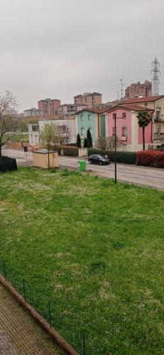 pole zielonej trawy obok ulicy z budynkami w obiekcie Casa Angela Parma w mieście Parma