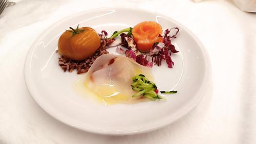 a white plate with food on a table at Hotel Queen Mary in Cattolica