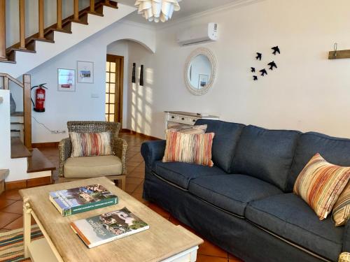 a living room with a blue couch and a table at PIER HOUSES by Nature Bliss in Vila Nova de Milfontes