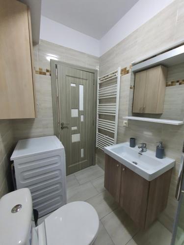 uma casa de banho com um WC branco e um lavatório. em Angi House Otopeni em Otopeni