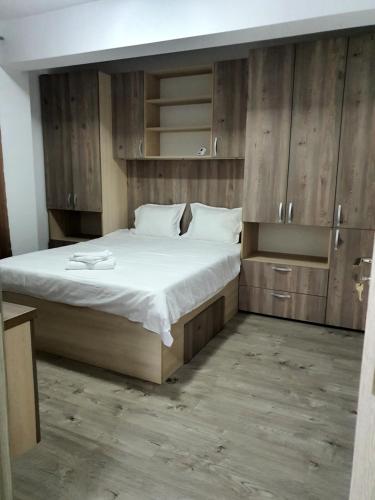 um quarto com uma cama grande e armários de madeira em Angi House Otopeni em Otopeni