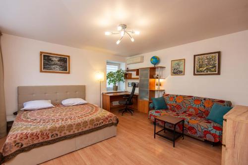 sypialnia z łóżkiem i kanapą w obiekcie Nidos Laivas w mieście Nida