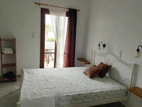 a white bed in a room with a window at Παραθαλασσιο στουντιο Μιχαλιας Sea view studio Michalias Νουμερο 8 in Agia Marina Aegina