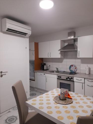 a kitchen with a table and a kitchen with white cabinets at Apartments Donella in Umag