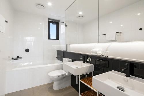 uma casa de banho branca com um lavatório, um WC e uma banheira em CASSA OPERA - Spacious 3B Apartment in the Heart Managed by The Cassa em Brisbane
