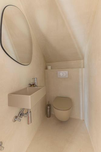 a bathroom with a sink and a toilet and a mirror at Casa Mano Tribunj with beach in Tribunj