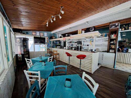 a restaurant with blue tables and chairs and a counter at Elba Travels - Morcone in Capoliveri