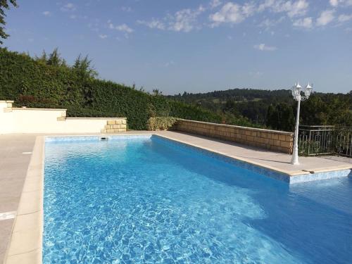 une grande piscine avec de l'eau bleue dans une cour dans l'établissement La petite colline du Cros, villa à louer, à Saint-Pierre-de-Chignac