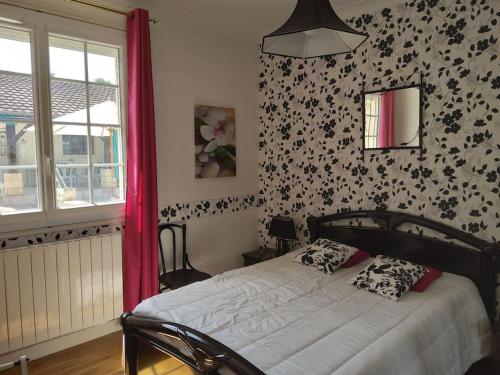 a bedroom with a bed with a black and white wallpaper at La petite colline du Cros, villa à louer in Saint-Pierre-de-Chignac