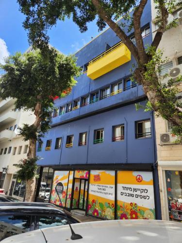 un edificio azul al lado de una calle en Ninna palatin en Haifa