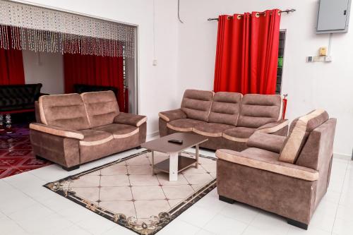 two chairs and a table in a living room at D'BALI HOMESTAY - Private Swimming Pool, NETFLIX, Internet Wifi ,Cuckoo, Internet Wifi , Dryer, Washing Machine, Aircond Setiap Bilik & Ruang Tamu in Pasir Puteh