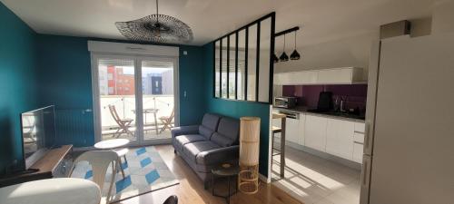a living room with a couch and a kitchen at Cozy apartment at Paris doors with free car-park in Saint-Denis