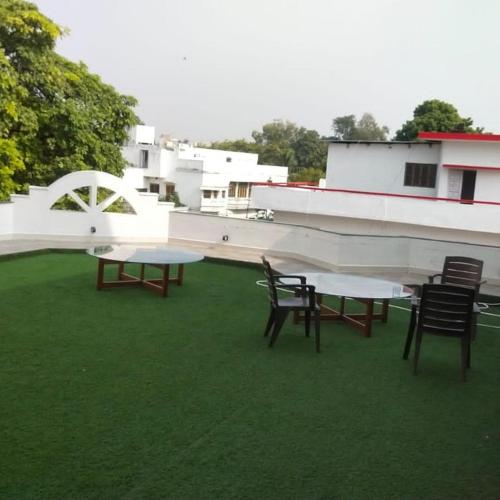 two tables and chairs on the roof of a building at Mauji's Villa Hotel & Guest House in Prayagraj